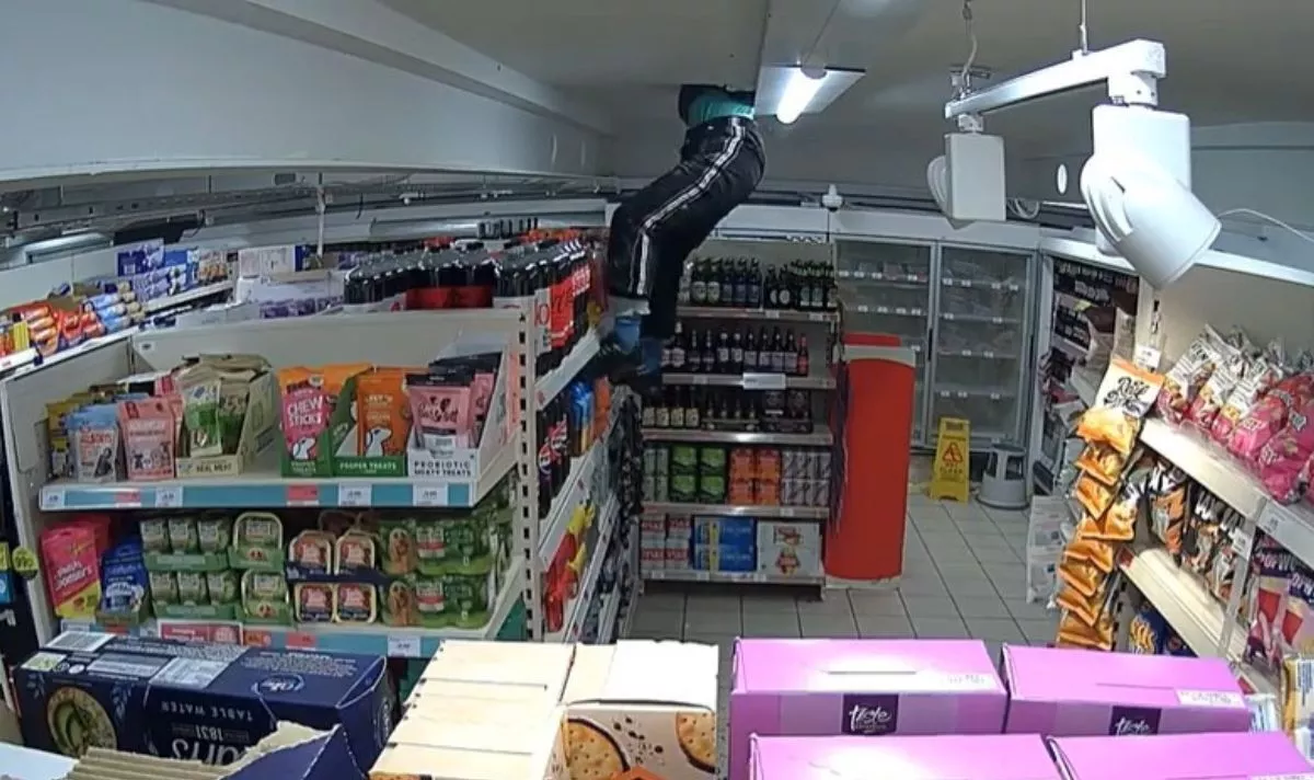 Insane moment burglar dangles from hole in Sainsbury's ceiling during break-in